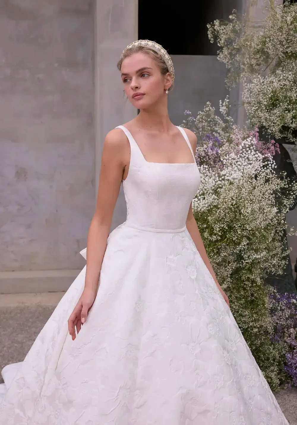 model is wearing a sleeveless wedding gown