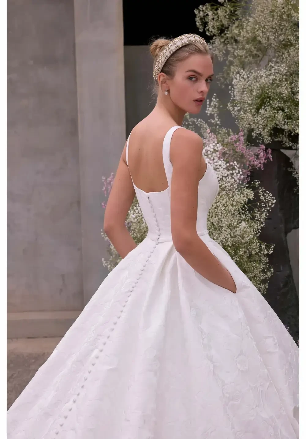 model is wearing a sleeveless wedding gown