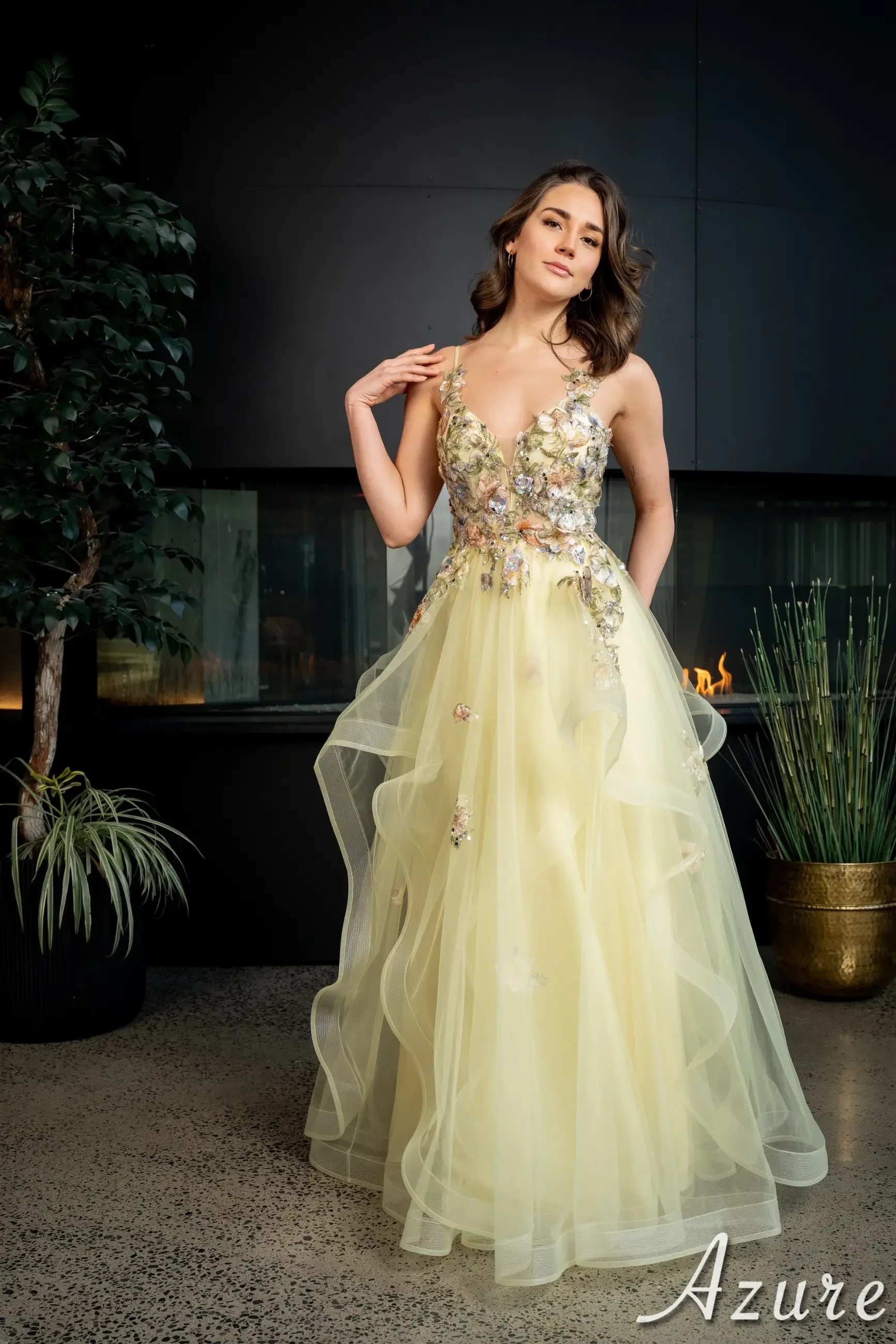 model is wearing an embellished yellow prom dress