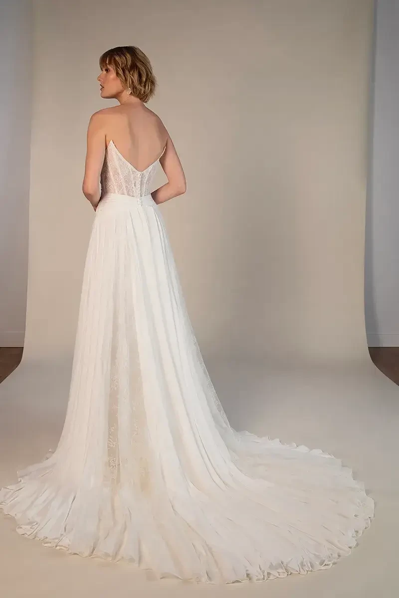 model is wearing an off the shoulder chiffon long sleeve wedding dress