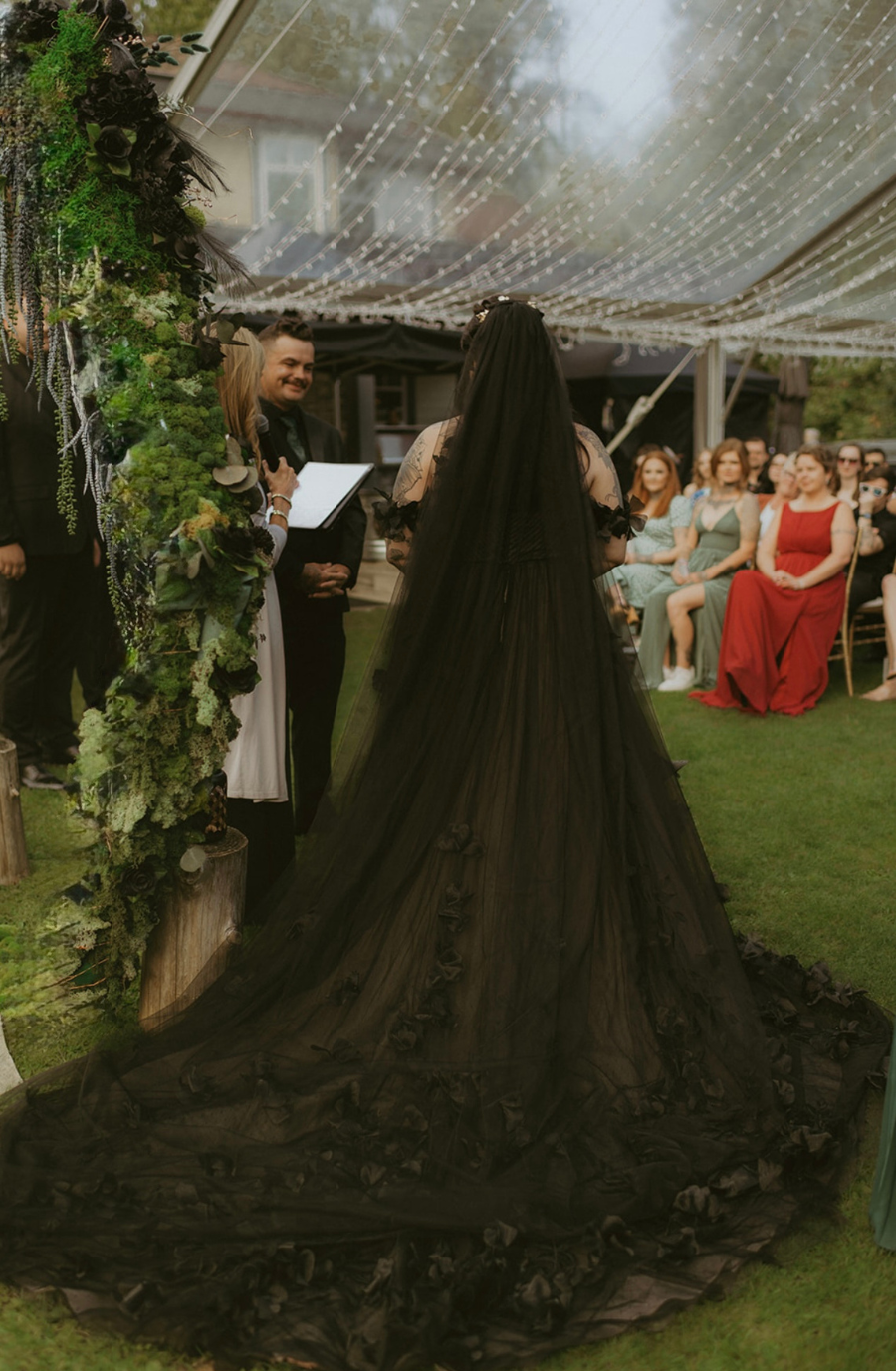 model is wearing a black lace a-line bridal gown